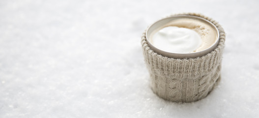 Obraz na płótnie Canvas cup of hot drink in a sweater on the snow