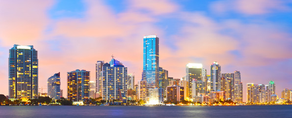 Obraz premium Miami na Florydzie, zachód słońca nad panoramą miasta ze światłami na nowoczesnych wieżowcach w centrum miasta