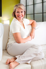 Senior woman relaxing in modern apartment.