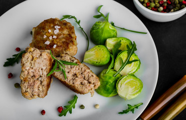 Fried pork meatballs served with brussels sprouts and arugula