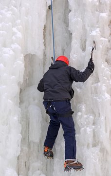 unidentifiable Ice climber climbing a frozen waterfall, in Ontario Canada