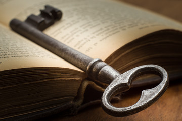 A key and an open old book - Una chiave e un vecchio libro aperto