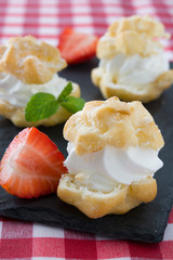 Profiteroles and strawberries on slate
