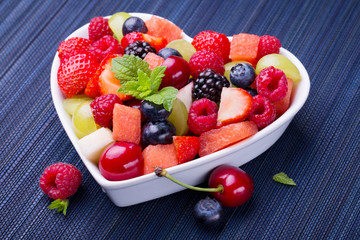 Delicious fruit salad in heart shaped bowl
