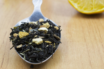 tea with lemon peel in a spoon on a table

