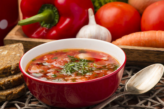 Borscht - traditional russian and ukranian beetroot soup in red bowl on wooden background.