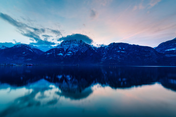 Mountain landscape at night. Sky is colored by the setting sun is reflected in the surface of the water.