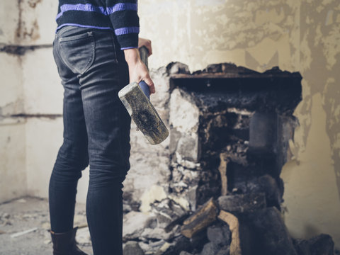 Woman opening up fireplace with sledge hammer