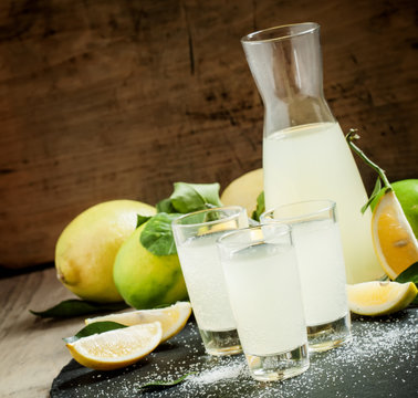 Homemade lemonade with lemon, lime, sugar and soda on a dark bac