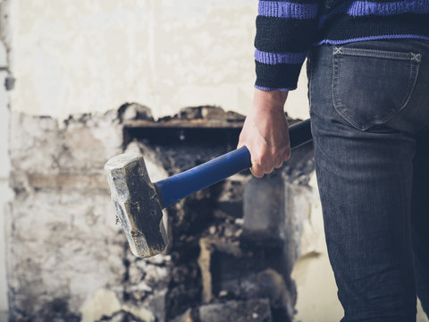 Woman opening up fireplace with sledge hammer