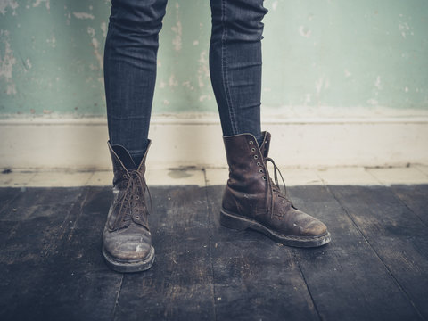 Person wearing boots standing in empty room