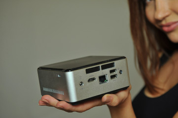 Model holding on hand  mini computer with all digital ports showing functionality - obrazy, fototapety, plakaty
