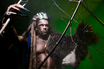 Werewolf with long nails among the branches of the tree and smok
