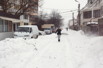 Street with lots of snow and walking woman