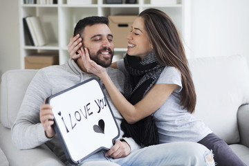 Young couple showing love message written on white board. I love you message. Valentines couple,shallow depth of filed