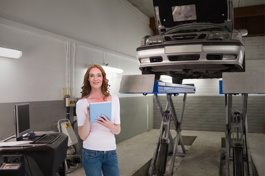 Composite image of pretty redhead using a tablet