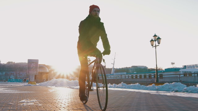 Guy riding fixed gear bike on background of the port, 4k