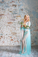 Charming young blond woman holding fresh flowers