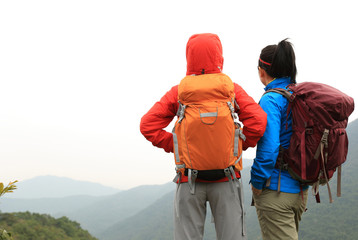 Obraz na płótnie Canvas two successful backpacker enjoy the beautiful landscape at mountain peak