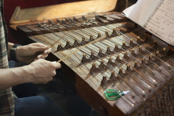 hands of musician playing dulcimer at chinese opera theatre