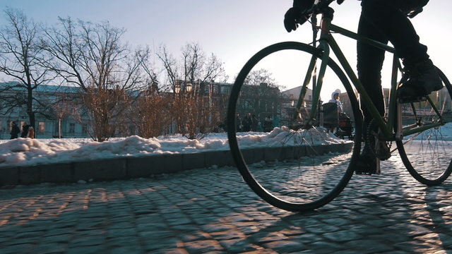 Young man riding fixed gear bike in city centre, super slow motion