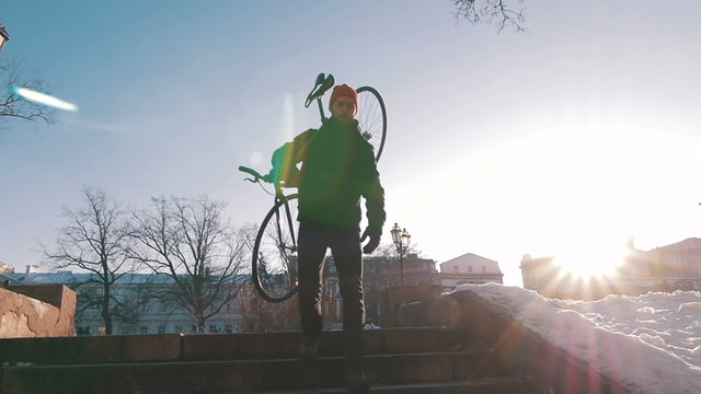 Guy carrying a fixed gear bike and getting down the steps,super slow motion