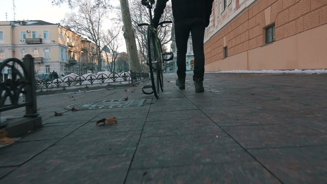 Young man going by the street with fixed gear bike in city centre,slow motion