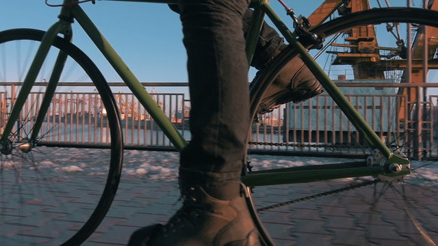 	Guy riding fixed gear bike in marine station, close up, slow motion