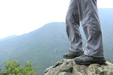 young woman hiker hiking at mountain peak
