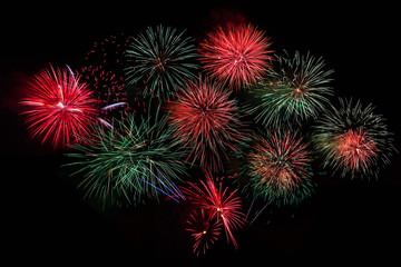 Colorful fireworks of various colors over night sky. Celebration beautiful colorful fireworks, red green salute with dazzling display in the night sky background. 4 of July, Independence day, New Year