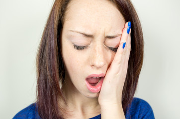 girl suffering from toothache on a white background