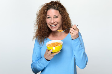 Vivacious young woman eating breakfast cereal