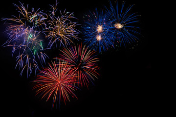 Celebration beautiful colorful red golden blue fireworks, salute with dazzling display in the night sky background. A large fireworks event. Sparks. 4 of July, Independence day, New Year. Copy space