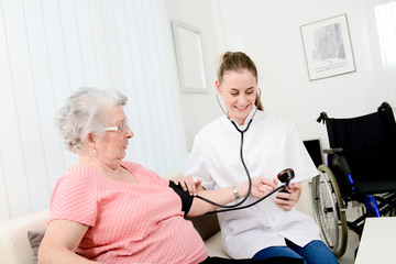 Obraz premium elderly senior woman with a young doctor having medical care at home