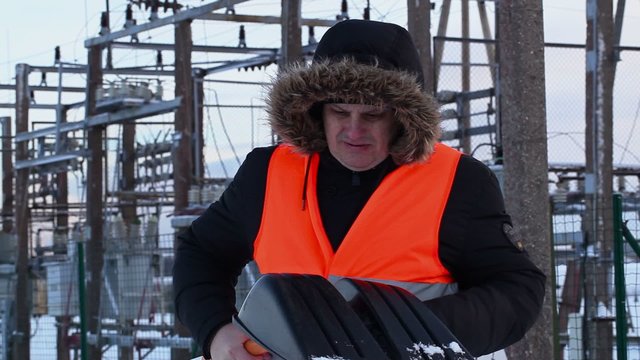 Electrician checking snow shovel at power plants in winter