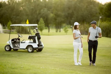 Foto auf gebürstetem Alu-Dibond Golf Junges Paar am Golfwagen