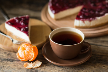 Wedge of classic new york style cheesecake with cup of tea and mandarins, Homemade bakery recipe or menu background