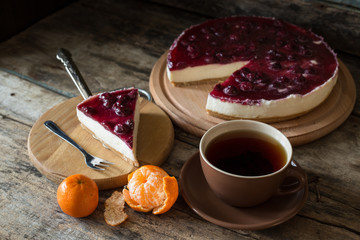 Wedge of classic new york style cheesecake with cup of tea and mandarins, Homemade bakery recipe or menu background