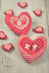 Two hearts hanging on wooden background