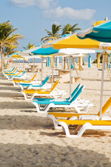 Colored umbrellas and deck chairs on the sandy beach