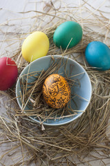 Fototapeta na wymiar Easter eggs in straw plate on a white background