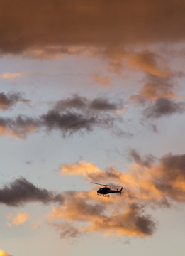 Helicopter is flying in the sunset