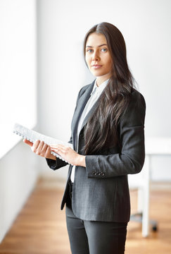 Portrait of young beautiful business woman with documents in the