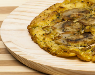 Omelette mushrooms on a wooden plate
