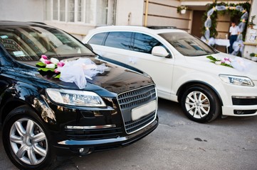 wedding cortege of two black and white cars
