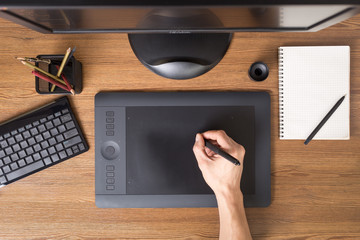 Designer workspace with tablet, keyboard, computer