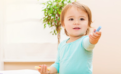 Happy toddler girl playing with chalk