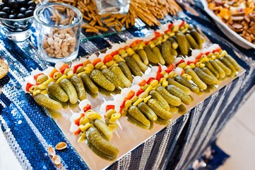 Fototapeta premium pickled cucumbers and cherry tomatoes at sea table on wedding