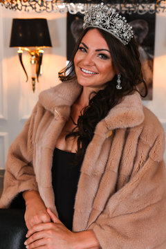 Portrait of Miss Russian Universe 2015 contest winner Anna Sizykh in fur coat wearing tiara.