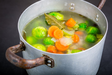 Brussels sprouts soup in a pot on black wooden table